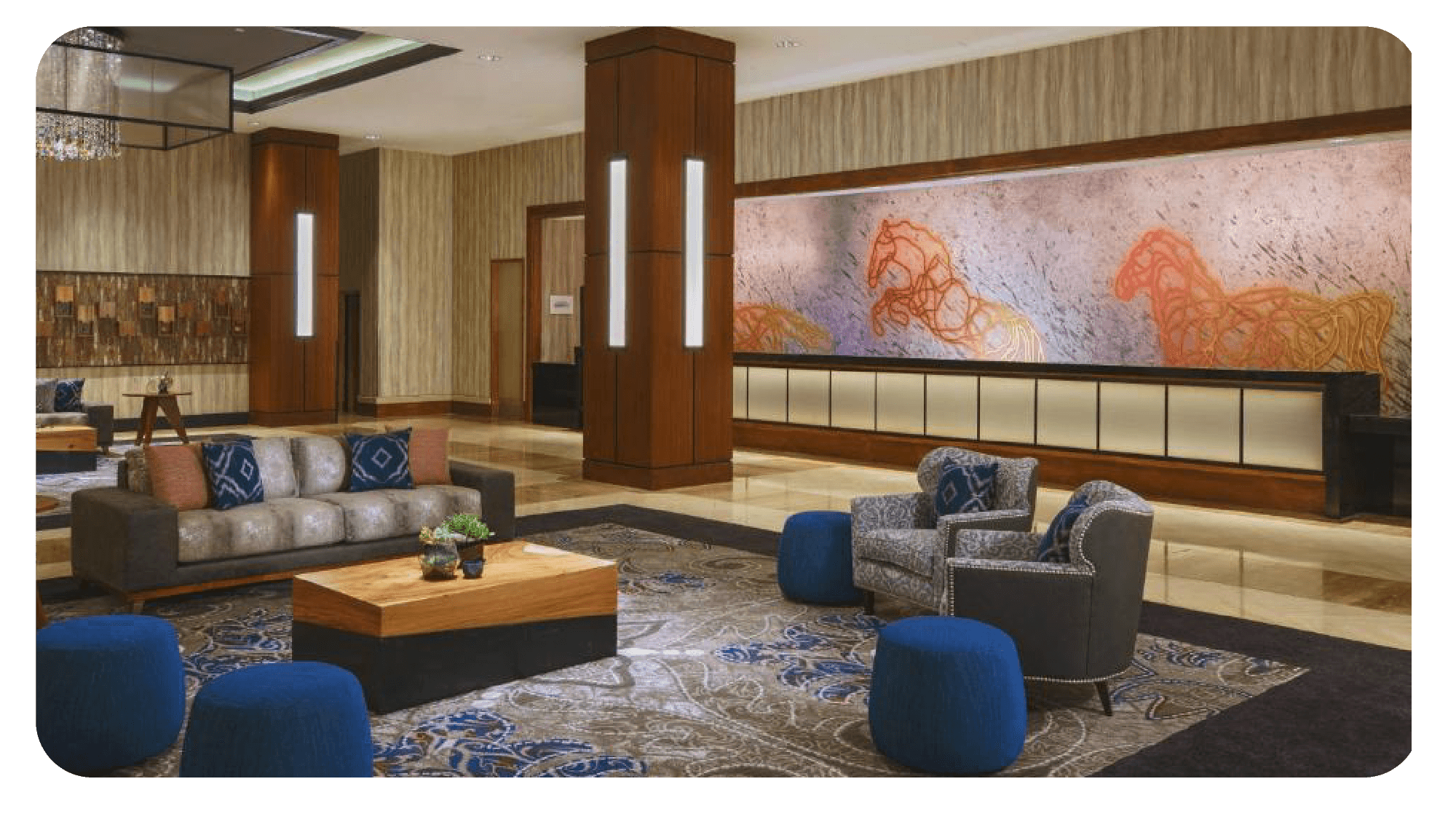 Elegant hotel lobby with plush seating, wooden accents, and anchor-themed artwork on the walls.