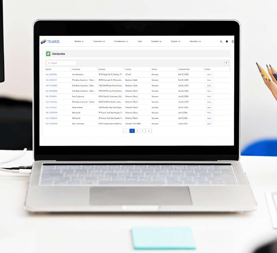 A laptop on a white desk displays a Telarus ClearQuotes dashboard, a powerful tool for Sales Applications, showing a table of quotes with columns for reference, customer, address, service, status, and date. A person's hand holding a pencil is visible on the right.